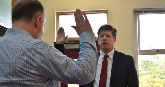 Clayton Franke / The Daily World
Dr. Jim Shank, right, takes the superintendent oath of office at a North Beach School District Board of Directors meeting on Tuesday, June 20. He was sworn in by board President Jeff Albertson.