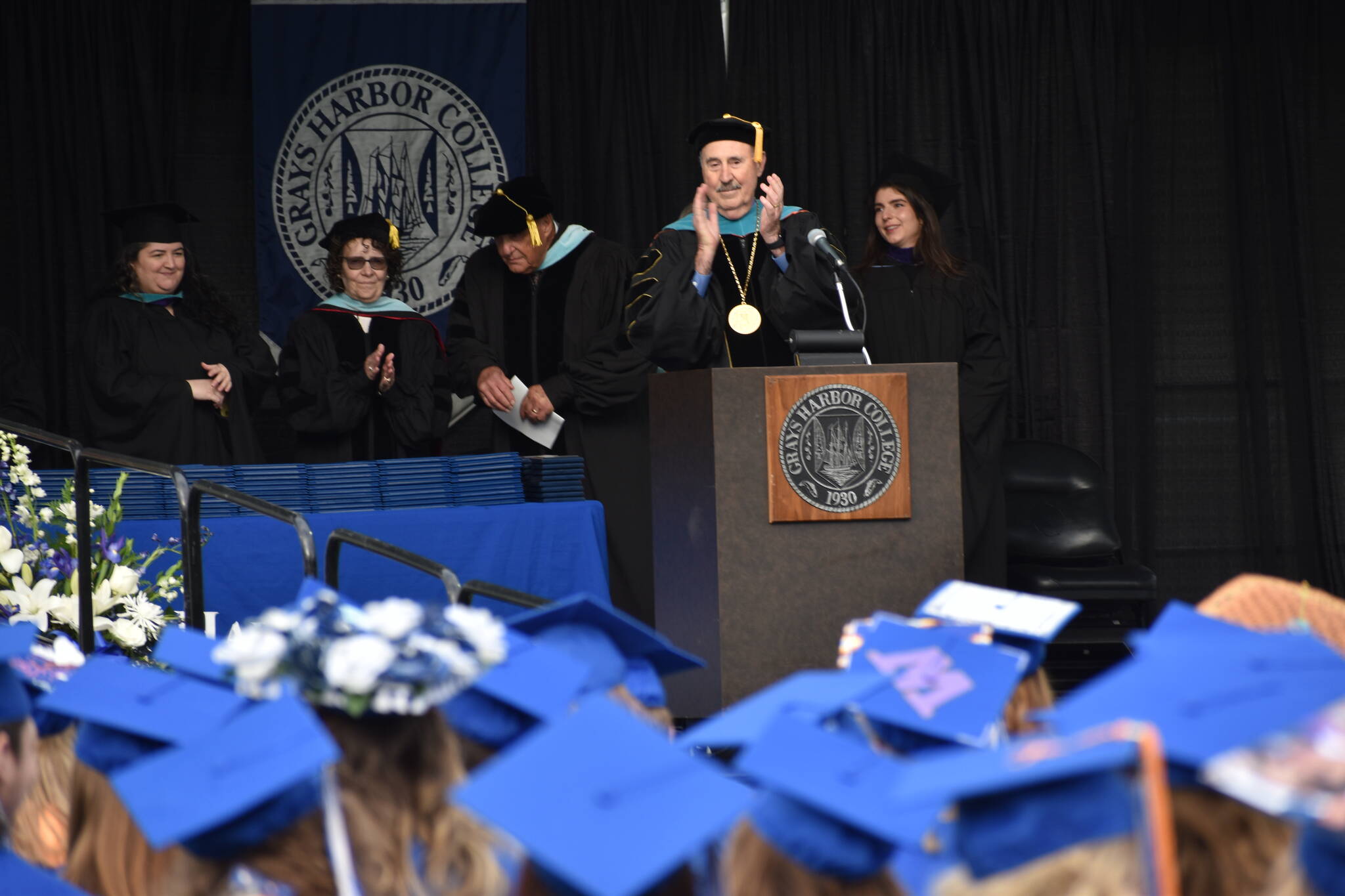Clayton Franke / The Daily World
Dr. Ed Brewster, outgoing president of Grays Harbor College, claps for graduates at a commencement ceremony Friday, June 23.
