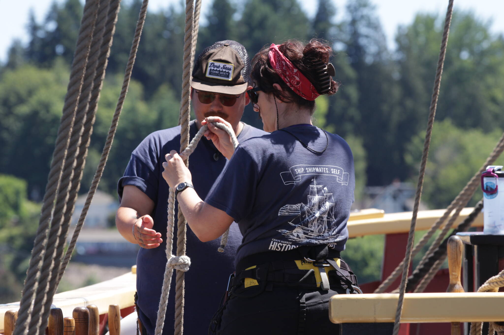 The Lady Washington’s Chief Mate James Hsu, left, works with Marijo Gauthier-Bérubé as she takes part of a program where nautical archaeology graduate students familiarize themselves with practical sailing aboard the Lady Washington. (Michael S. Lockett / The Daily World)