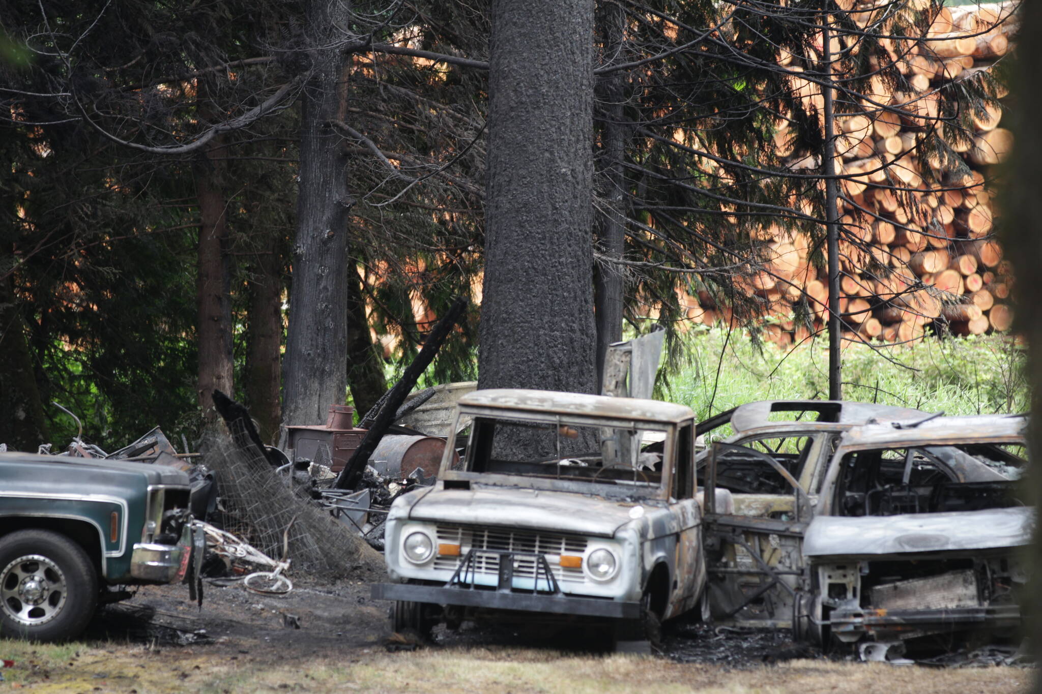 Charred trees and cars give mute testimony to a fire that threatened to grow out of control near Elma on Saturday. (Michael S. Lockett / The Daily World)