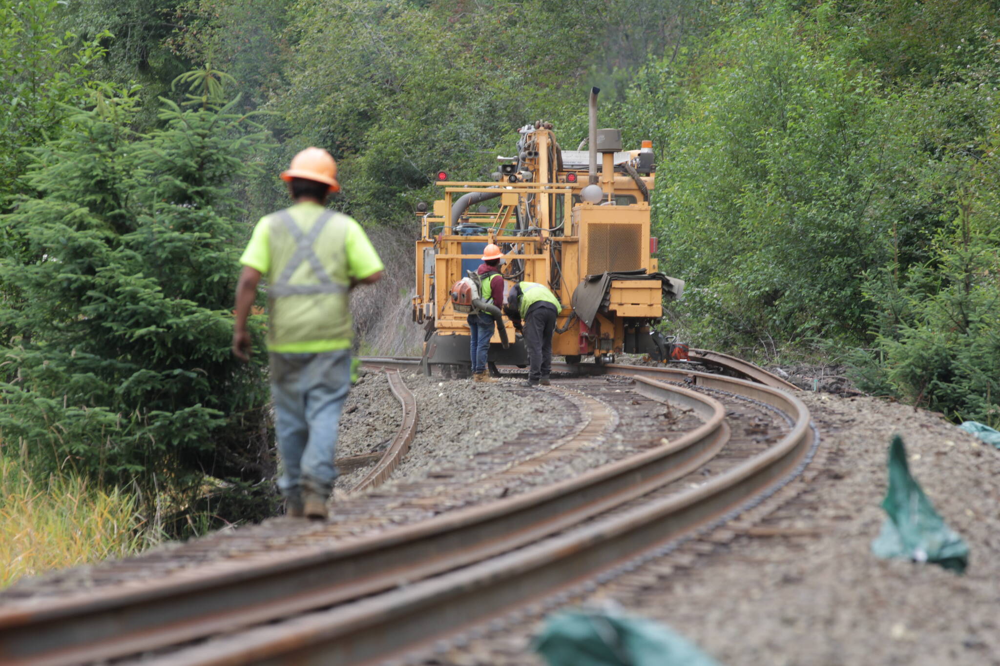 A worker walks down railroad in Central Park as Puget Sound and Pacific Railroad replaces old tracks with newer continuously welded rail on July 12. (Michael S. Lockett / The Daily World)