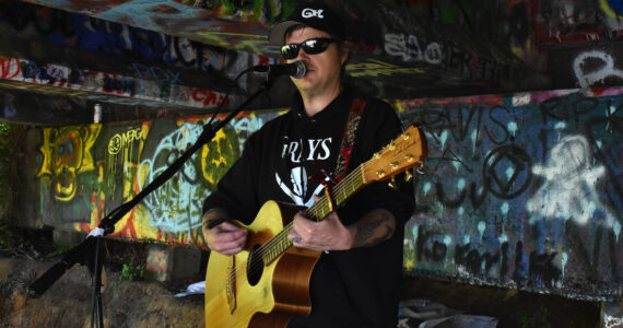 Matthew N. Wells / The Daily World
Clinton “Dogger” Mullins plays under the Young Street Bridge in early June. Mullins is pre-releasing his new album “Atta Bomb” on Saturday via the major streaming services. He’ll also sell a CD version of the pre-release at his live shows. People who buy the pre-released CD will be able to exchange it for the album with the finished details.
