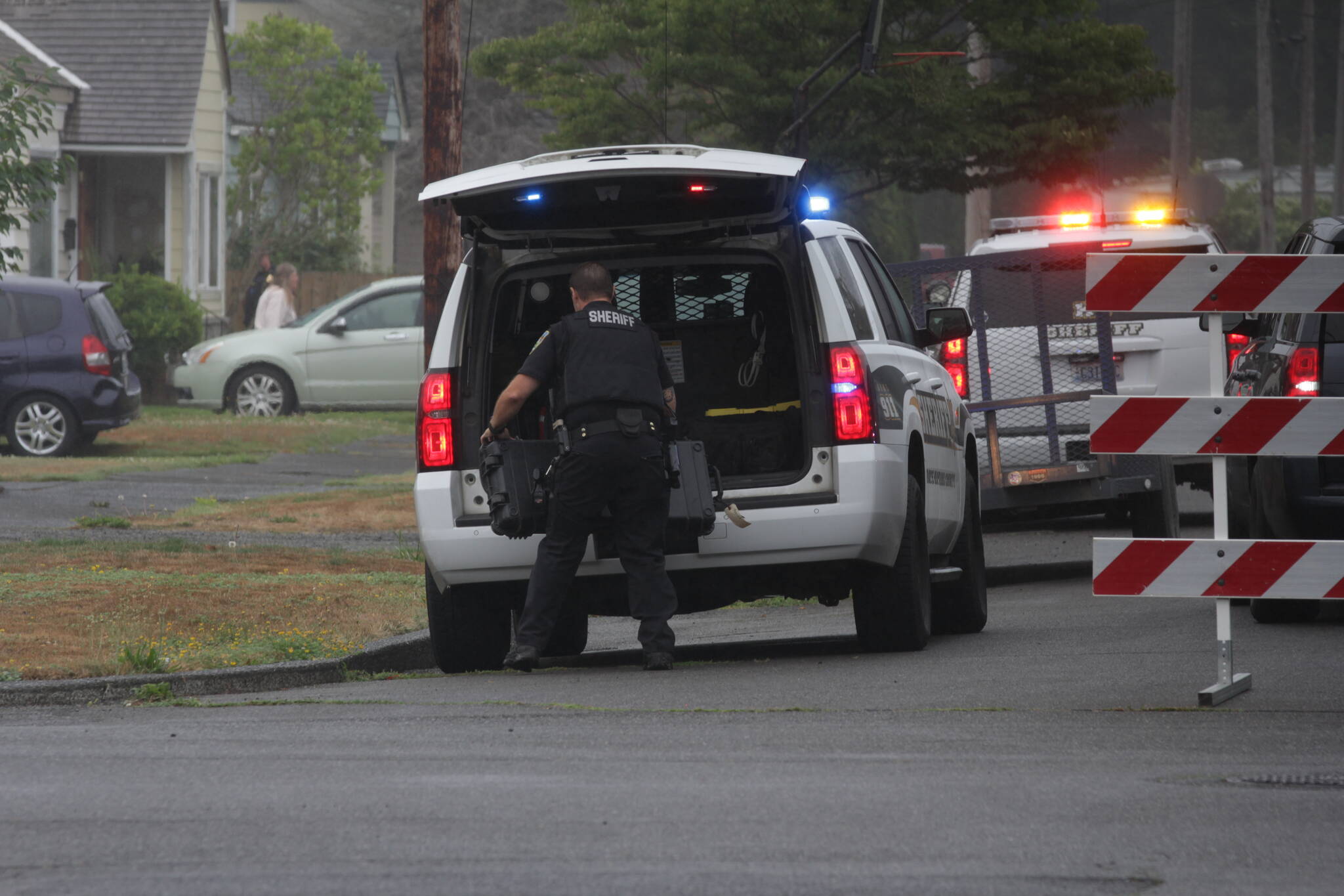 Michael S. Lockett / The Daily World
A sheriff’s deputy pulls an equipment case out of a vehicle during a standoff in Hoquiam on Aug. 28.