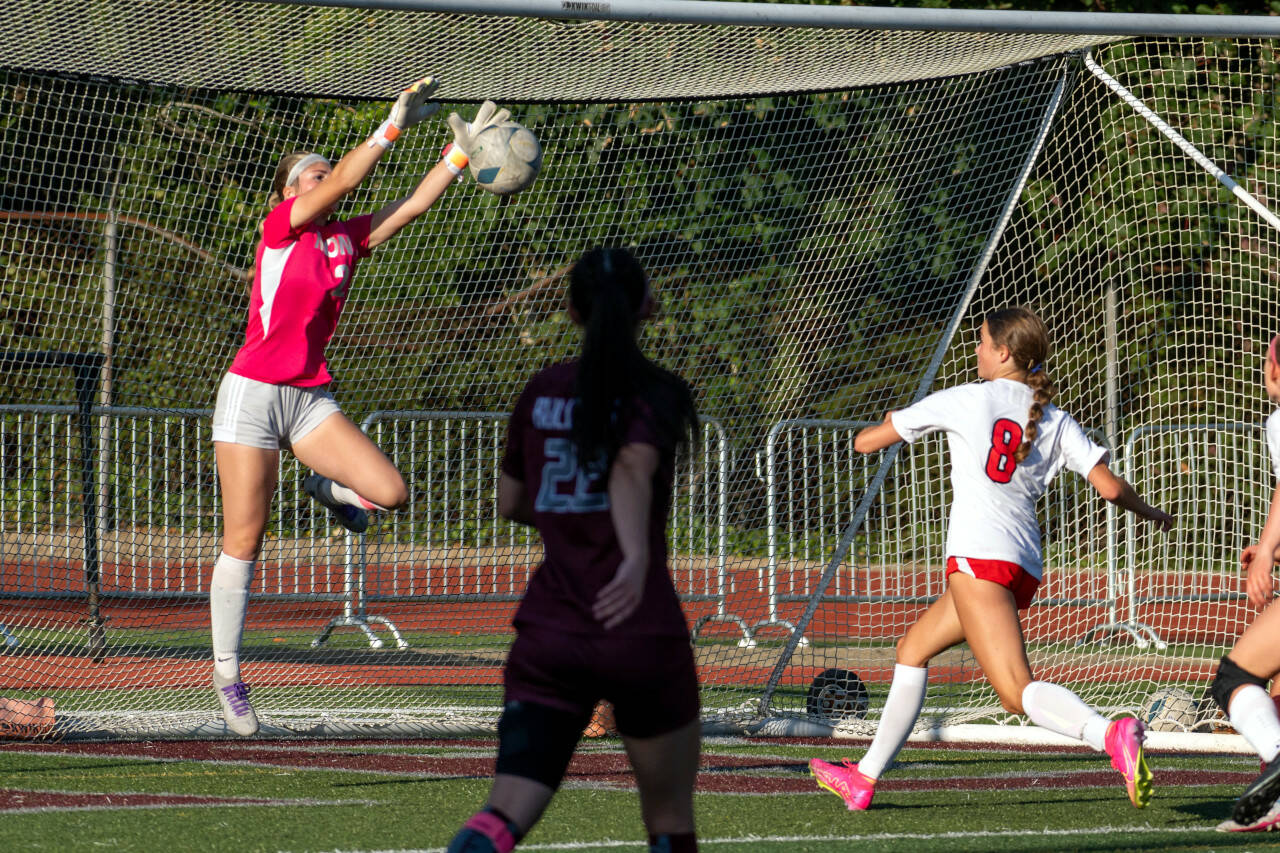 PHOTO BY FOREST WORGUM Montesano goal keeper Riley Timmons, left, leaps for a save in the face of oncoming Seattle Academy forward Isla McNae (8) during a 2-1 victory (4-2 on penalty kicks) over Seattle Academy on Saturday in Montesano.