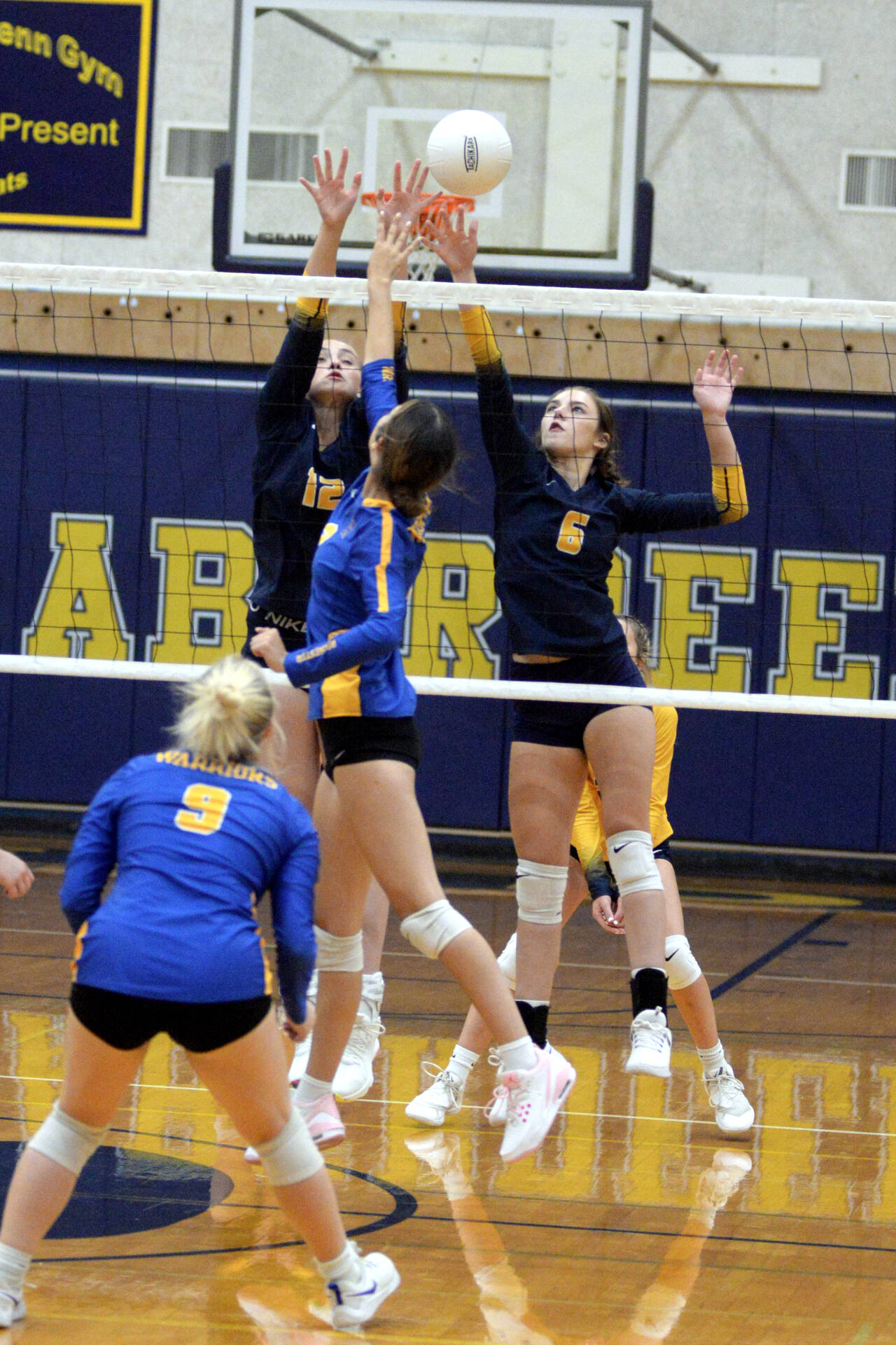 RYAN SPARKS | THE DAILY WORLD Aberdeen’s Lilly Camp (12) and Savannah Strickland (6) defend a shot by Rochester’s Taylor Koehn during the Bobcats’ straight-set victory on Thursday at Sam Benn Gym in Aberdeen.