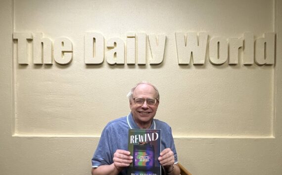Matthew N. Wells / The Daily World
Rick Anderson, former sports editor for The Daily World, holds his first published book, “Rewind: A Half-century of Classics, Cult Hits and other Must-see Movies.” Anderson was effusive in his praise of former newspaper coworkers John Hughes, Doug Barker, Kat Bryant, Janet Simmelink and Jeff Burlingame for their assistance through his career and for helping him to get his book proofread and published.
