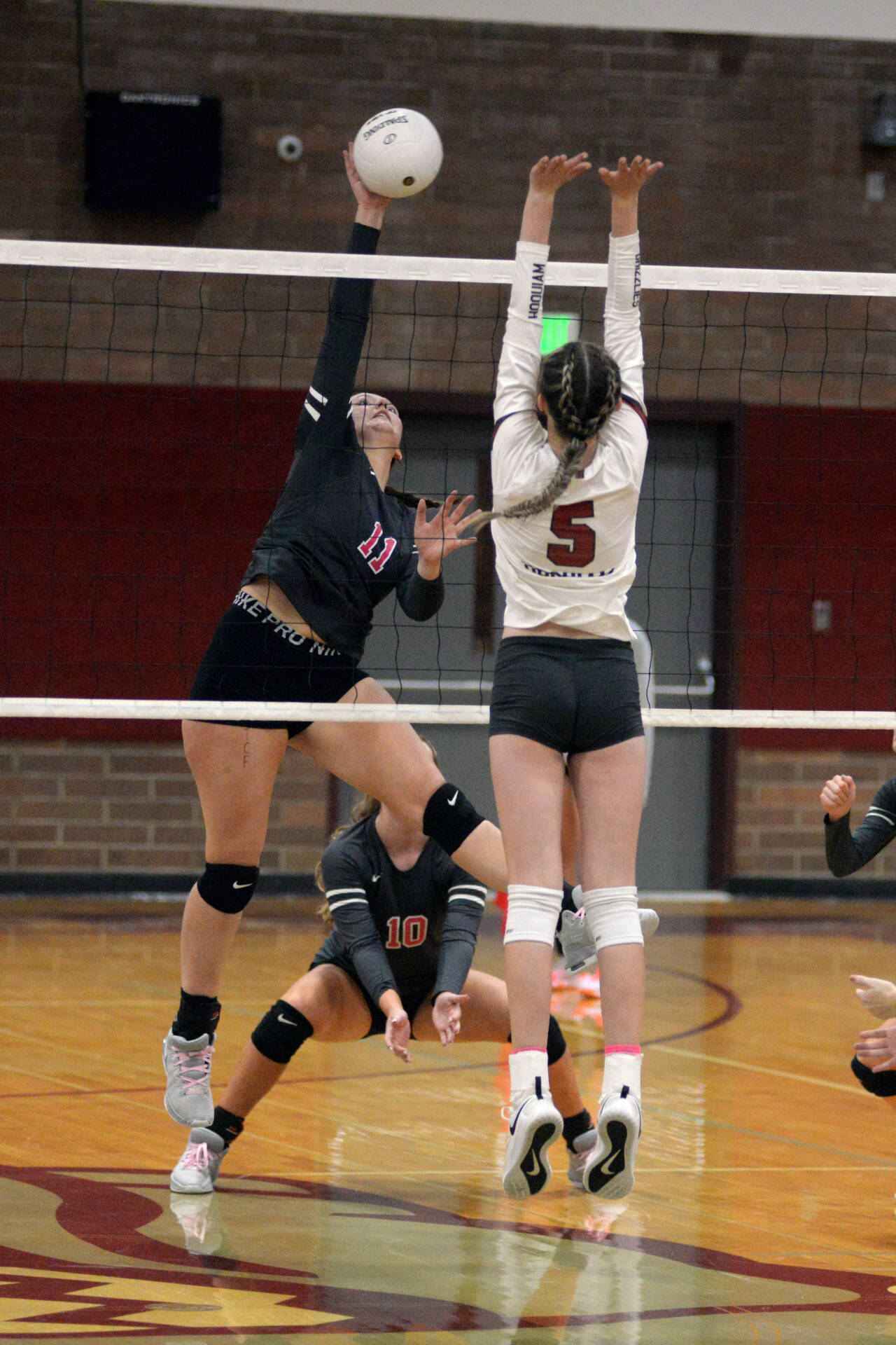 RYAN SPARKS / THE DAILY WORLD 
Montesano middle blocker Kylee Widsom (11) records a kill against Hoquiam’s Hayden Brook-Andrew (5) during a 3-1 victory on Tuesday at Montesano High School.