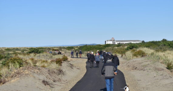 Walkers traverse the High Dune Trail on Saturday, Oct. 28. The new ADA-accessible trail in Ocean Shores affords wide views of the surrounding dune environment, the Pacific Ocean and nearby hotels. (Clayton Franke / The Daily World)
