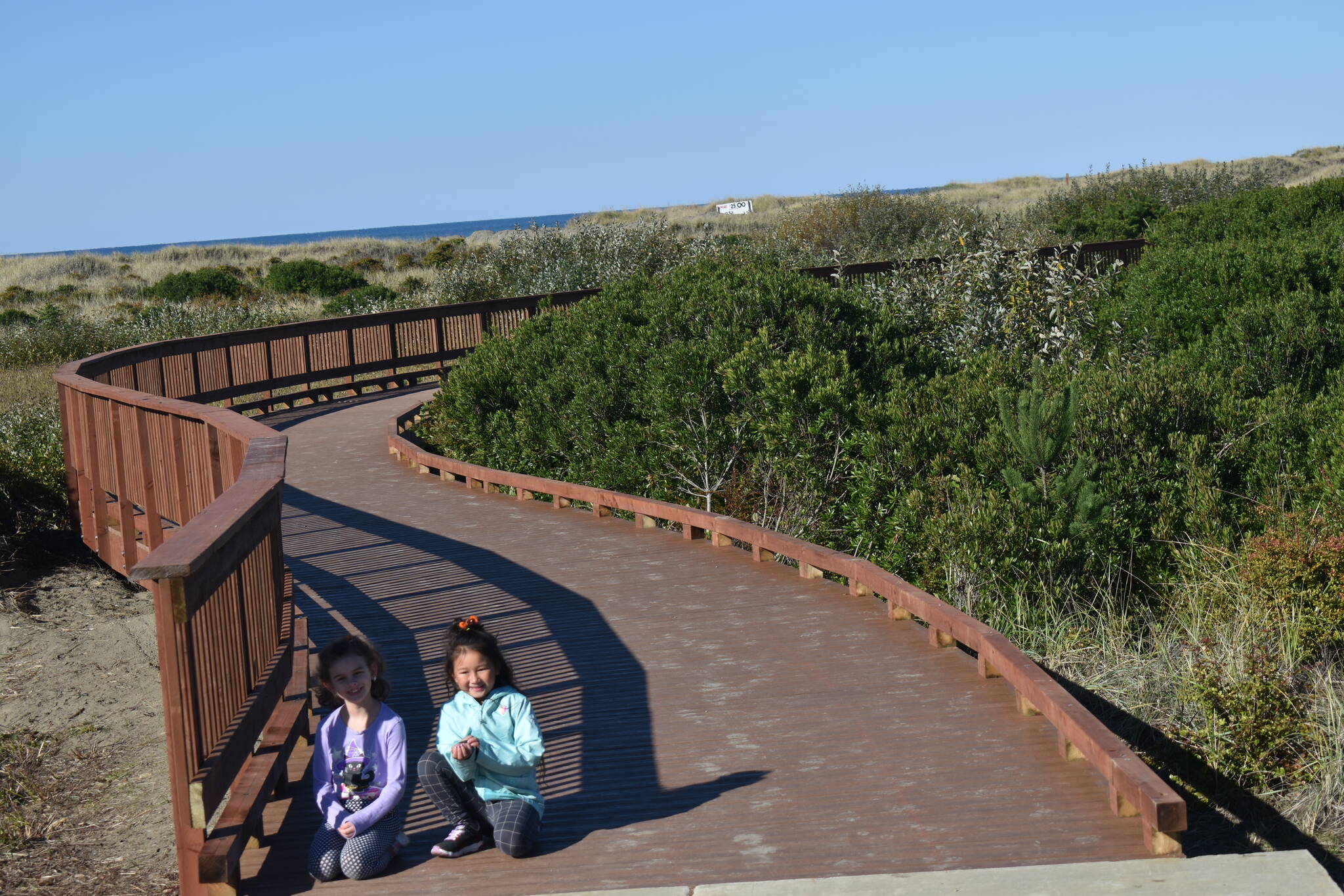 From left: Pheobee Bauman and Genavera Nguyen pose on the High Dune Trail on Saturday, Oct. 28. The trail contains about 335 feet of boardwalk. (Clayton Franke / The Daily World)