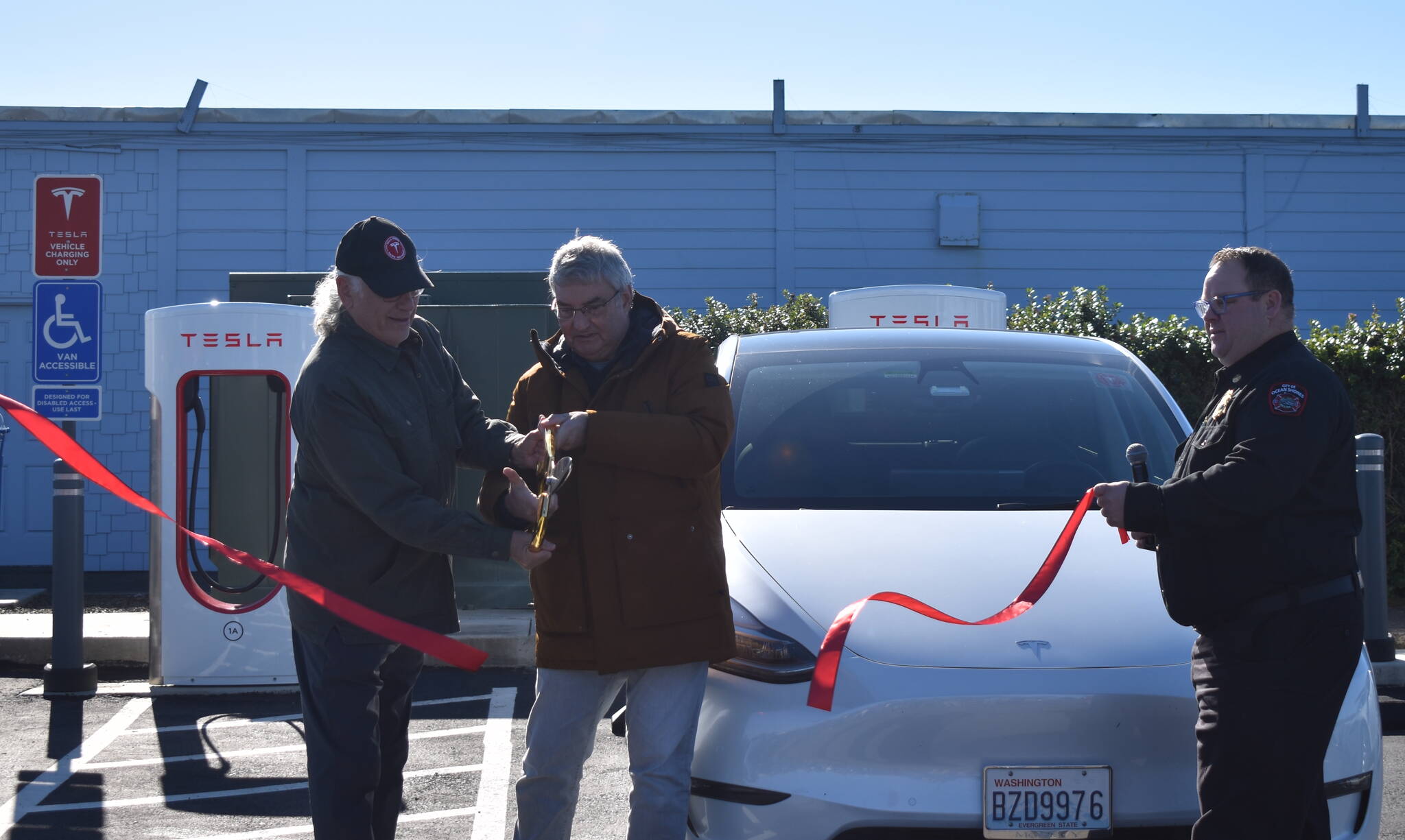 Clayton Franke / The Daily World
From left: Tesla owner Darrel Prowse, Ocean Shores Mayor Jon Martin and Fire Chief Brian Ritter cut the ceremonial ribbon for the Tesla Supercharger station in Ocean Shores on Saturday, Oct. 28.