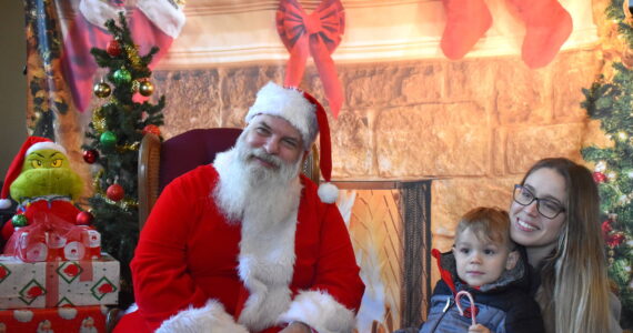 Matthew N. Wells / The Daily World
Santa Claus meets with Abram Veloni and his mom Taryn Veloni as The Grinch sits to the left of Ol’ Saint Nick. The Veloni family was impressed with Winterfest. “I didn’t know what to expect, but they have really blown us away,” Taryn said.