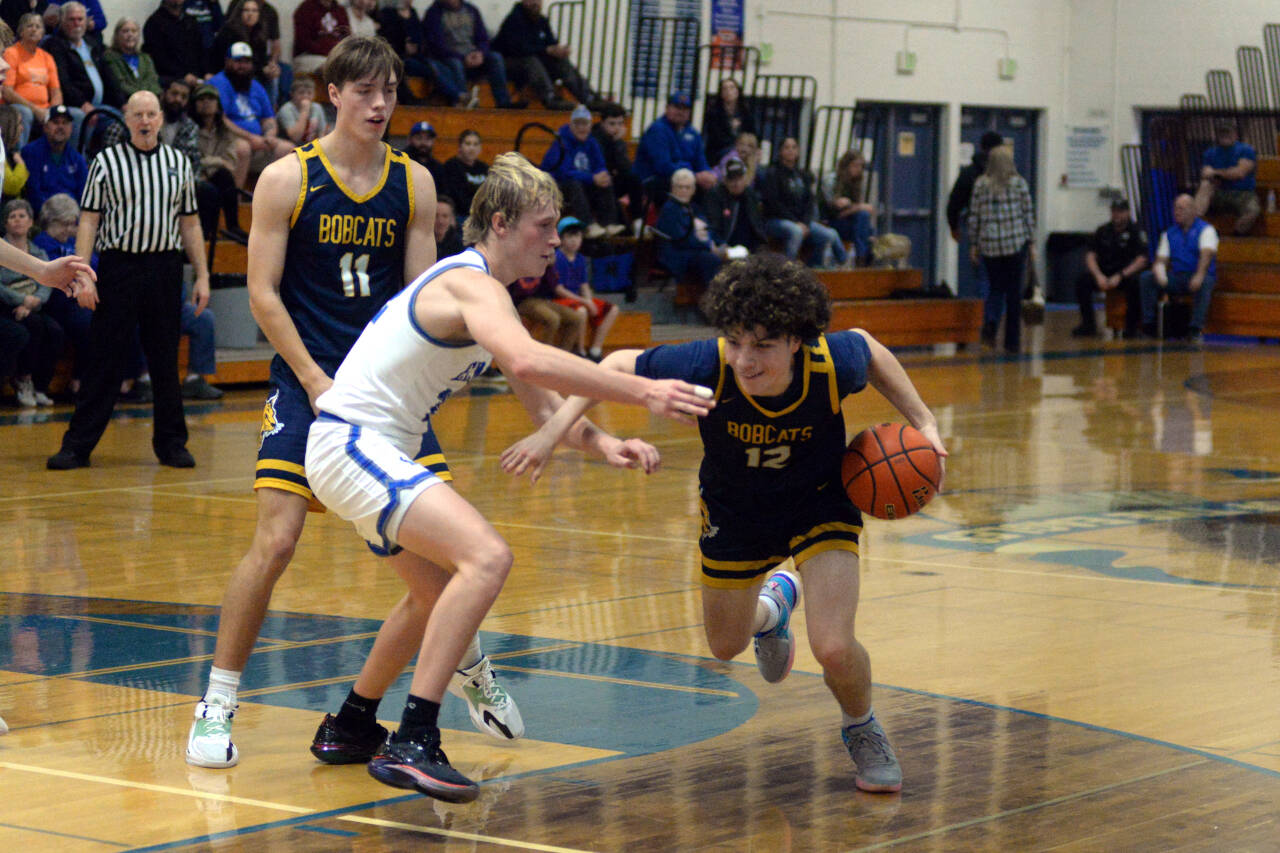 RYAN SPARKS | THE DAILY WORLD Aberdeen’s Manny Garcia (12) drives against Elma’s Cason Seaberg while the Bobcats’ Charlie Ancich (11) sets a screen during the Eagles’ 64-51 win on Tuesday in Elma.