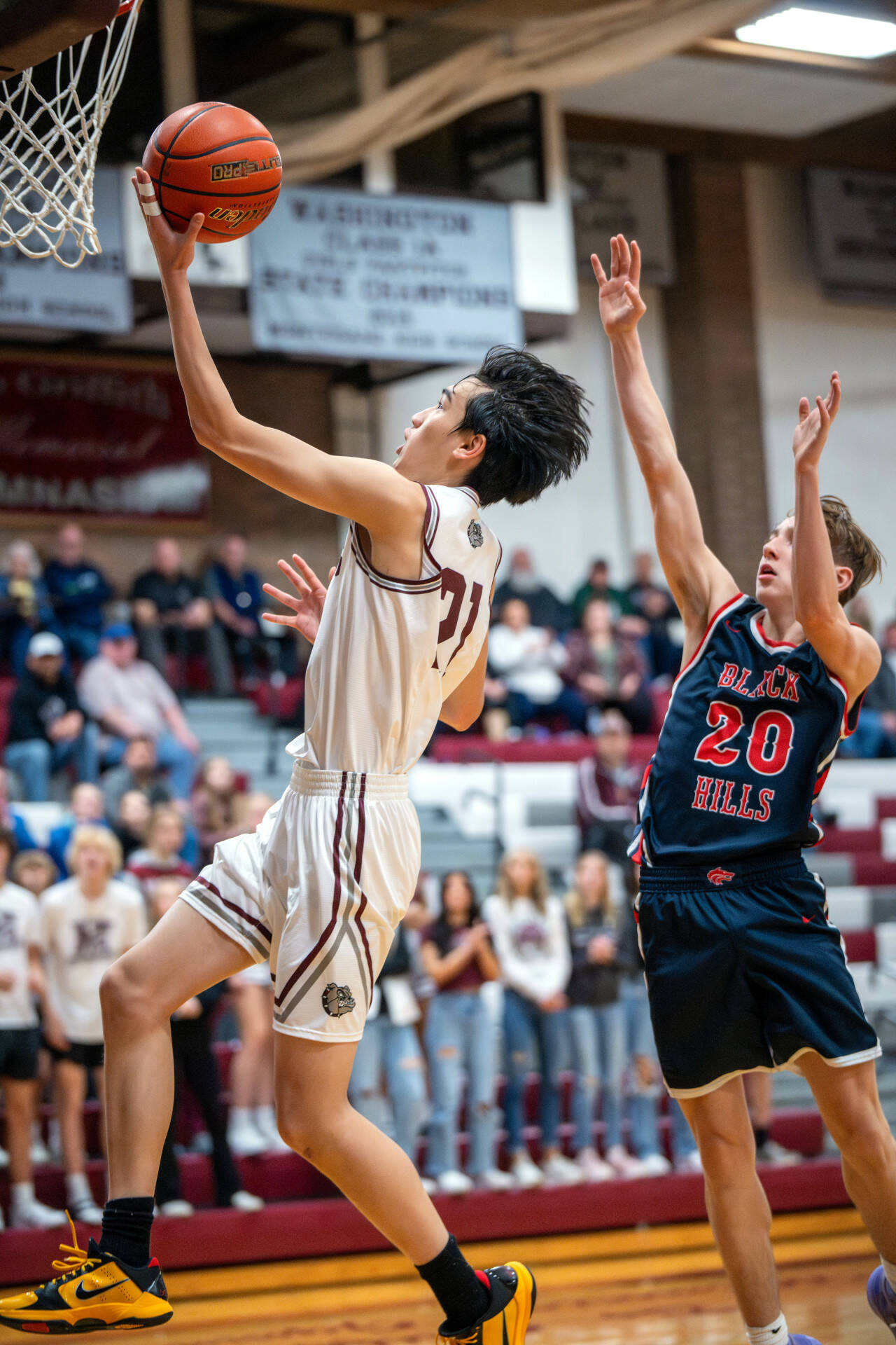 PHOTO BY FOREST WORGUM Montesano’s Delon Chan, left, glides to the basket while Black Hills’ Quinton Morrill during the Bulldogs’ 67-52 win in the Montesano Winter Classic on Friday in Montesano.