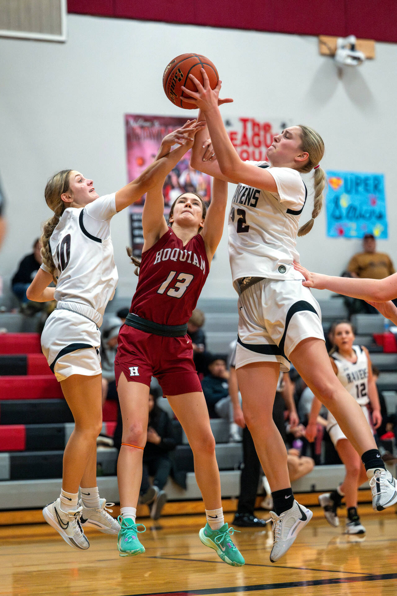 PHOTO BY FOREST WORGUM Raymond-South Bend’s Emma Glazier, left, and Kassie Koski, right, compete for a rebound against Hoquiam’s Katlyn Brodhead during the Ravens’ 49-17 win on Friday in Raymond.