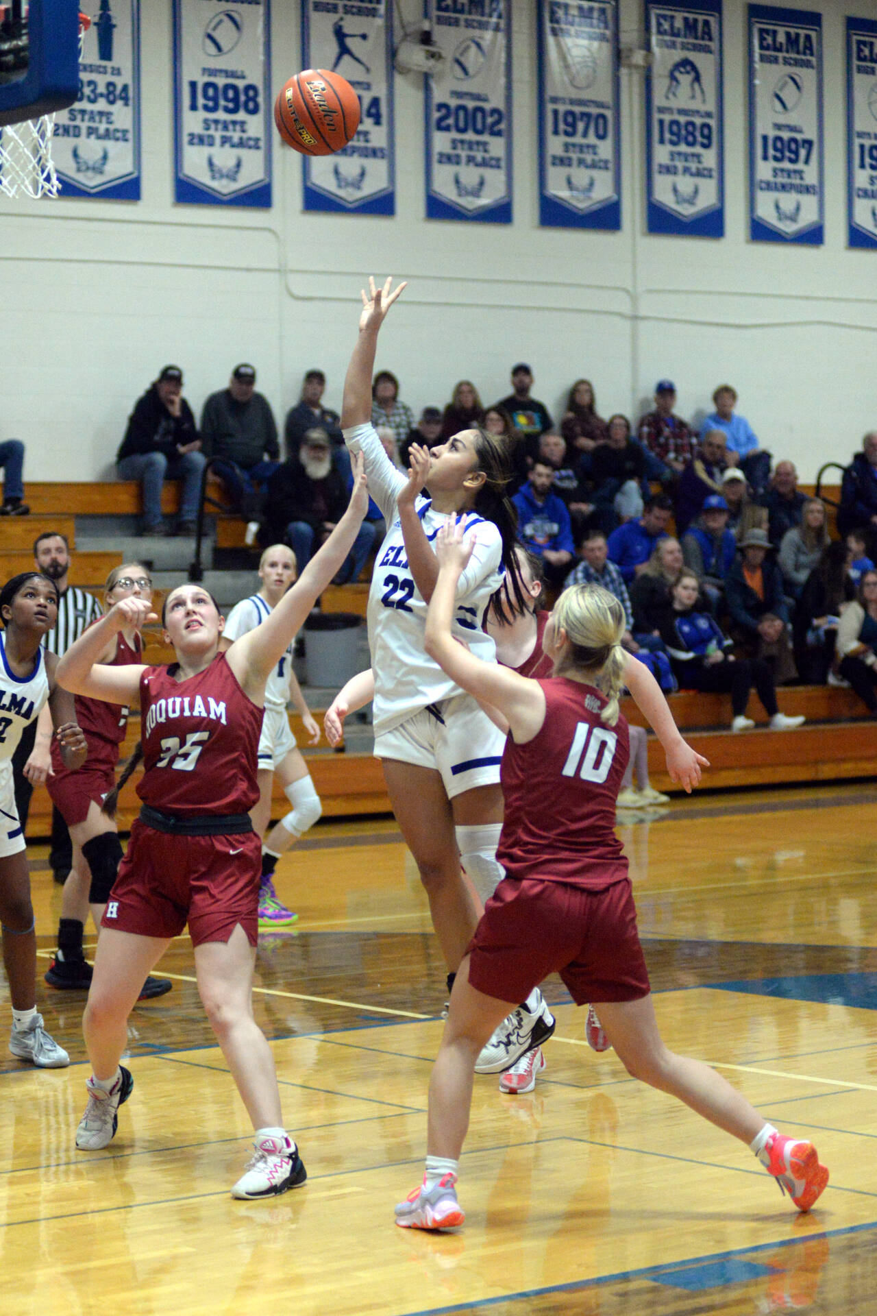 RYAN SPARKS | THE DAILY WORLD Elma’s Eliza Sibbett (22) scores on a floater against Hoquiam’s Dylan Little (35) and Ellie Graham (10) in the second half of the Eagles’ 46-30 win on Wednesday at Elma High School.