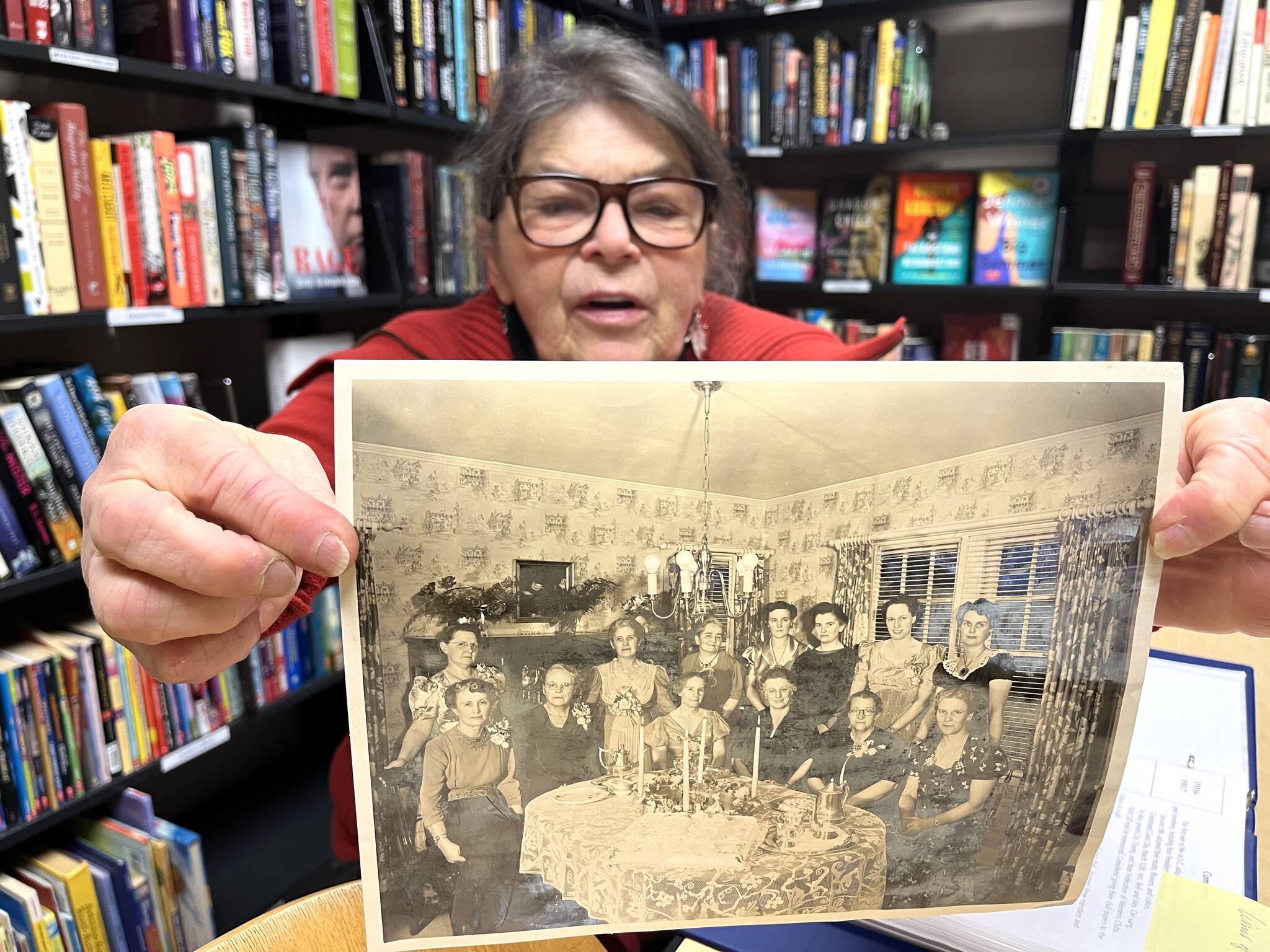 Joni Hildreth, a longtime member of the Monday Study Club, reads the caption on an archival photo from the 25th anniversary of the 107-year club. The club welcomes women who wish to spend significant time researching on interesting topics. After the research is done and a paper is written, they present their findings. Hildreth and her fellow members are happy to be part of a club where they can learn and socialize with other high-minded people. (Matthew N. Wells / The Daily World)
