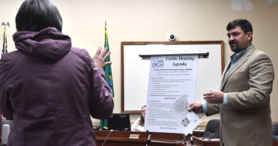 Montesano resident Donna Albert, left, talks with Dan Nelson, communications manager with the Olympic Regional Clean Air Agency, at a Jan. 16 public hearing at Hoquiam City Hall regarding a proposed wood pellet plant in Hoquiam.