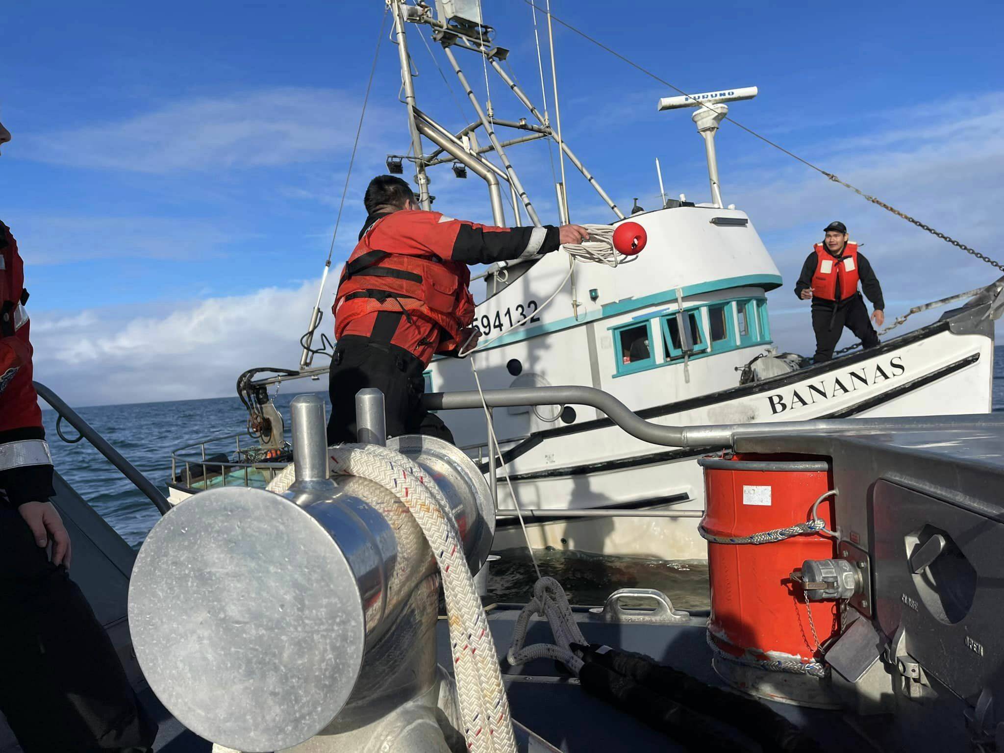 Coast Guardsmen toss a line to a disabled vessel before towing it in to Westport on Tuesday. (Courtesy photo / USCG)
