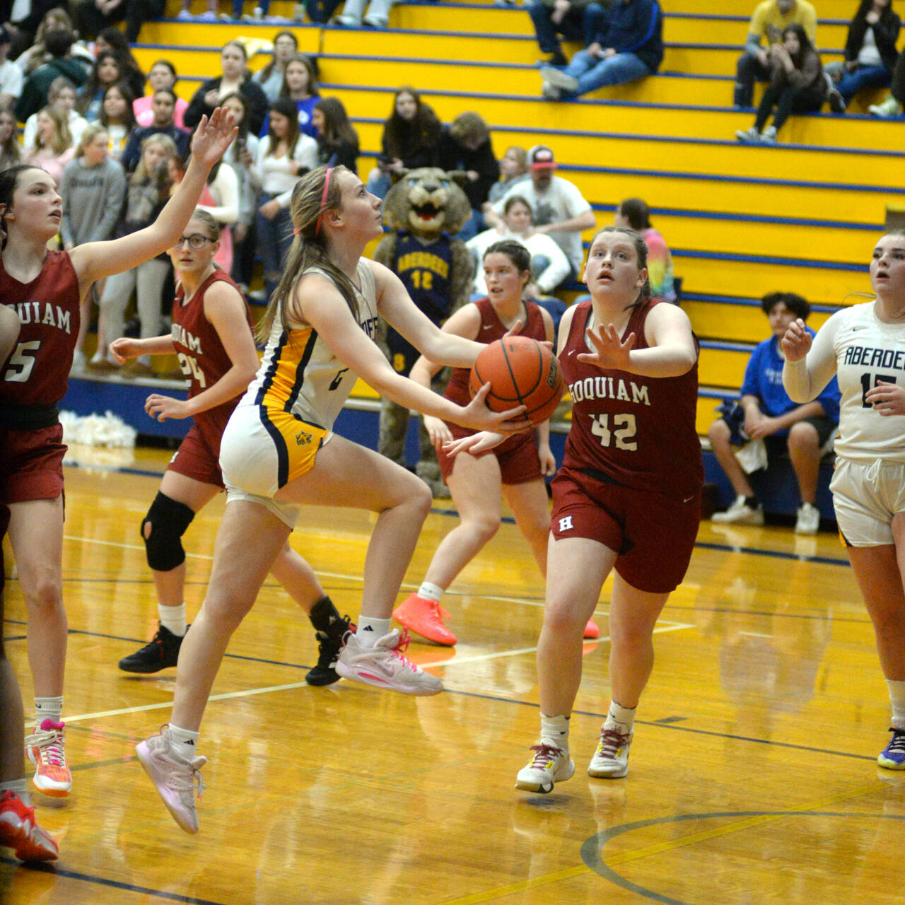 RYAN SPARKS | THE DAILY WORLD Aberdeen senior Annie Troeh, left, scores on a scoop shot against Hoquiam’s Sydney Gordon (42) during the Bobcats’ 55-25 win on Monday in Aberdeen.