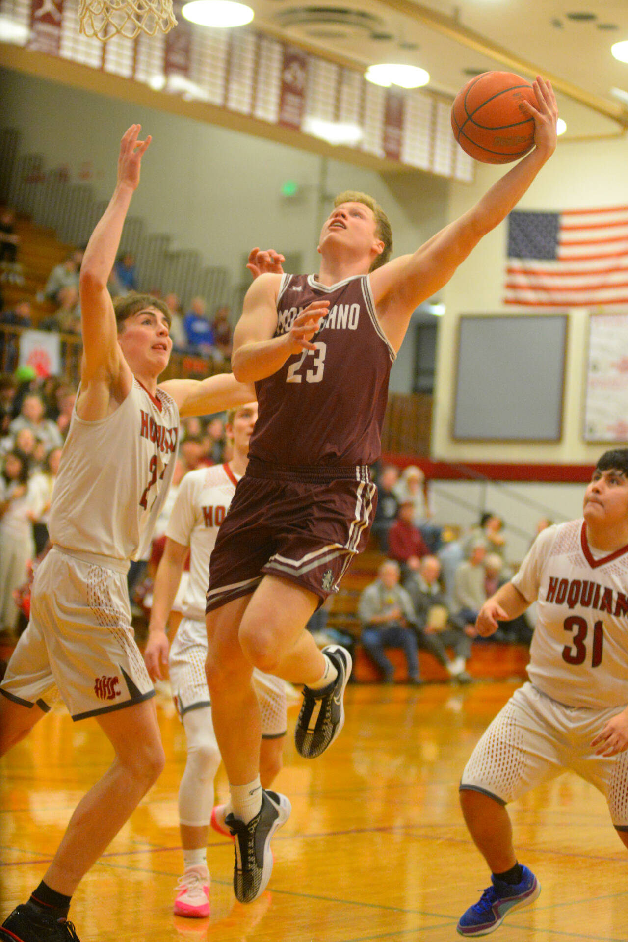 RYAN SPARKS | THE DAILY WORLD Montesano senior forward Tyce Peterson (23) drives to the basket against Hoquiam’s Chris Bryson (23) and Jose Fabian (31) during the Bulldogs’ 61-28 win over Hoquiam on Friday at Hoquiam High School.