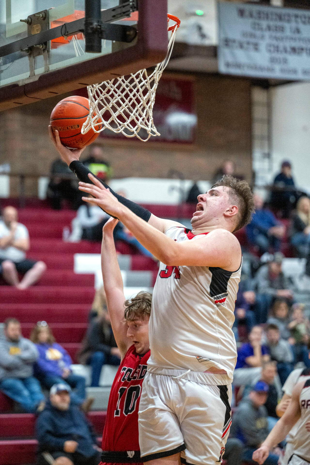 PHOTO BY FOREST WORGUM Raymond center Talan Yearout, right, drives to the hoop during a 60-49 loss to Toledo in a 2B District 4 Tournament first-round game on Saturday in Montesano.
