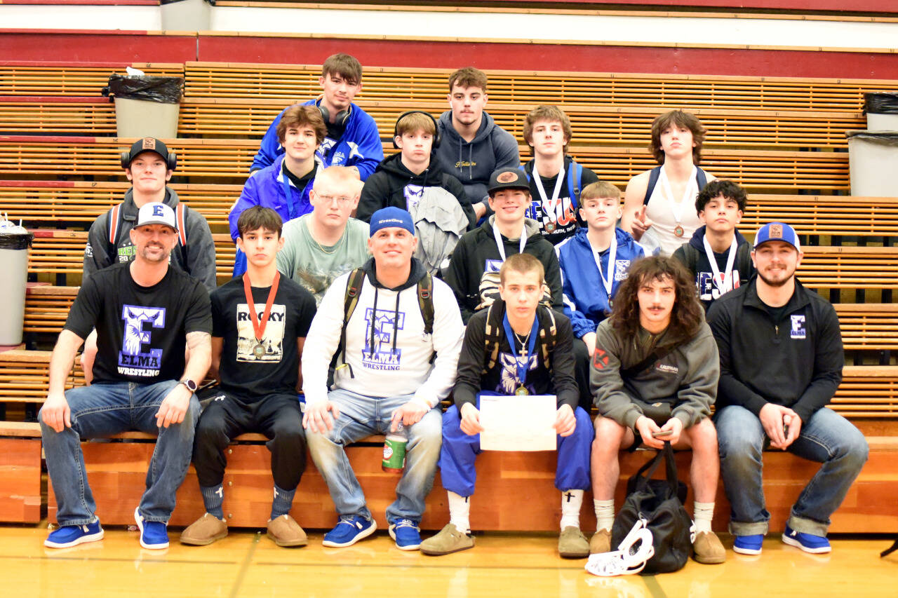 PHOTO BY SUE MICHALAK BUDSBERG Elma head coach Jeff Catterlin (front row, third from left) is surrounded by his team after the Eagles placed second at the WIAA Region 2 Tournament on Saturday at Hoquiam High School.