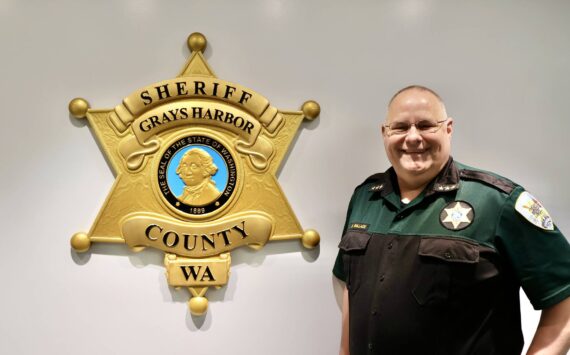 Michael S. Lockett / The Daily World
Sheriff Darrin Wallace stands alongside the agency’s new crest in their Montesano headquarters.