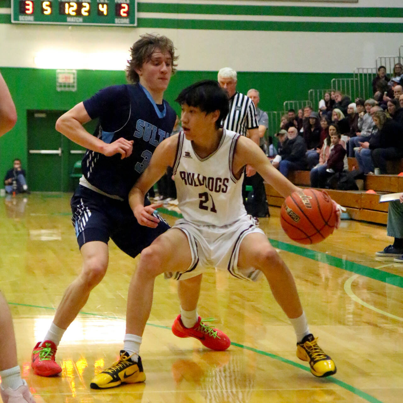 RYAN SPARKS | THE DAILY WORLD Montesano junior guard Delon Chan (21) dribbles against Sultan’s Tristan Lopez during the Bulldogs’ 69-54 loss in a 1A State first-round game on Saturday at Tumwater High School.