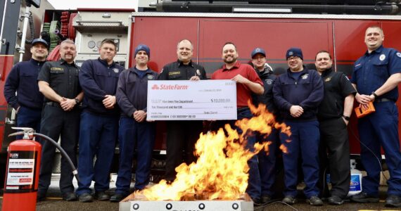The Aberdeen Fire Department received a $10,000 grant from State Farm for a fire extinguisher training aid, on fire in the foreground. (Michael S. Lockett / The Daily World)