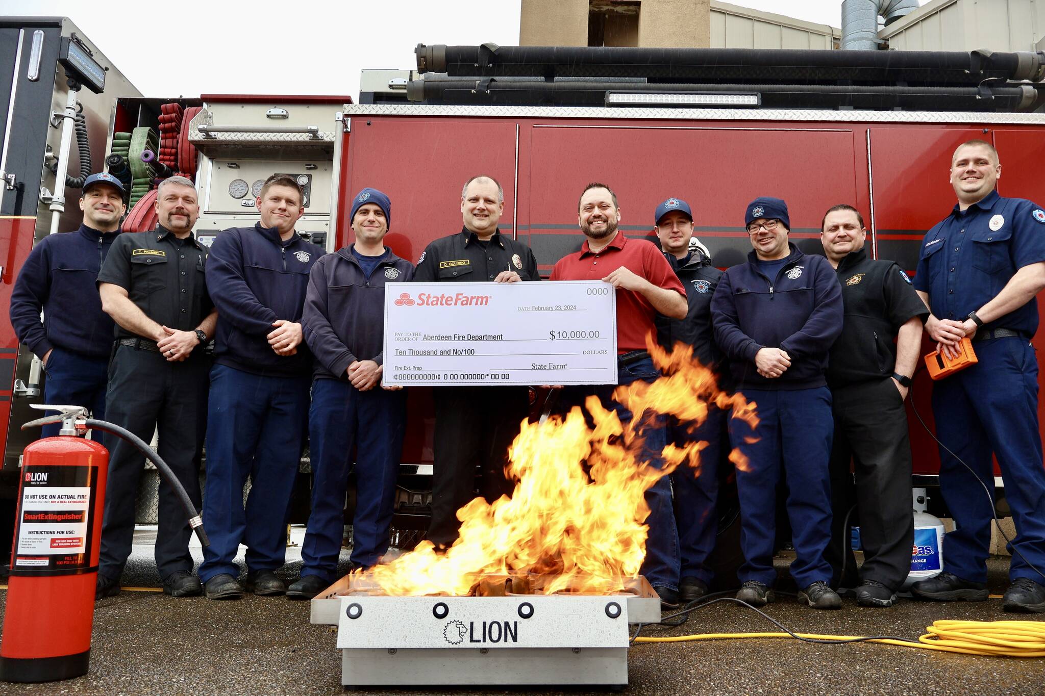 The Aberdeen Fire Department received a $10,000 grant from State Farm for a fire extinguisher training aid, on fire in the foreground. (Michael S. Lockett / The Daily World)