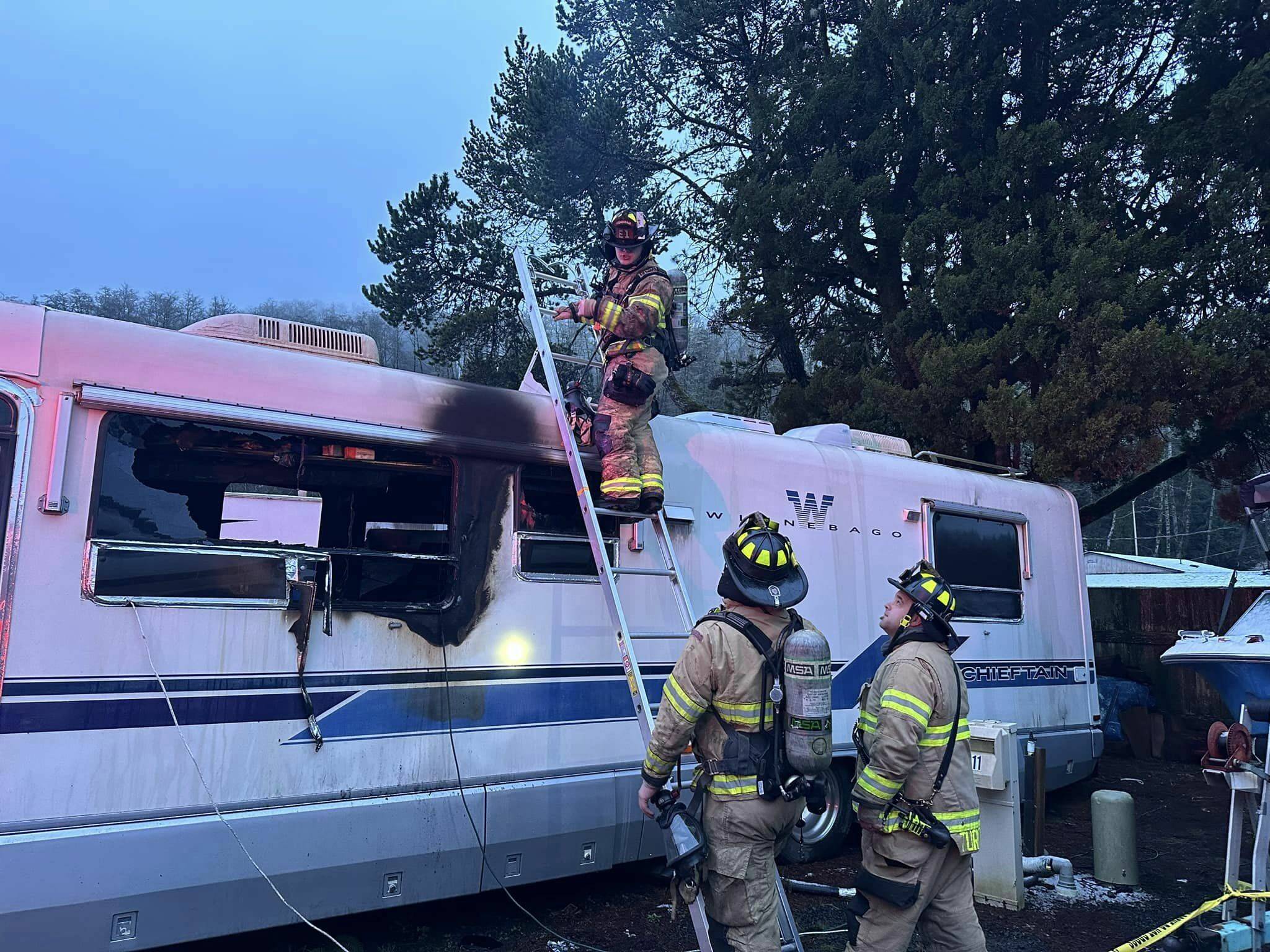Firefighters investigate a Hoquiam trailer after a fire swept through, killing the resident. (Courtesy photo / HFD)