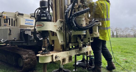 Clayton Franke / The Daily World
Emily Bayes, an assistant field geologist with ConeTec, the company hired to conduct soil stability assessments at the Hoquiam School District, operates a drilling machine at the Hoquiam High School baseball field on Feb. 21.