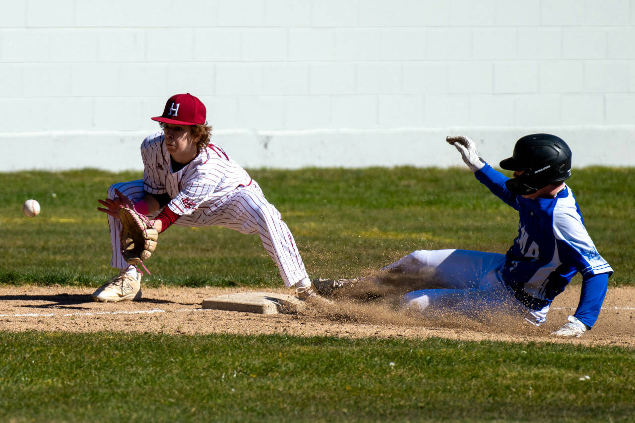 PHOTO BY FOREST WORGUM Elma’s Grant Vessey, right, slides into third while Hoquiam third baseman Trenton Graham receives the ball during a double header on Saturday at Olympic Stadium in Hoquiam.
