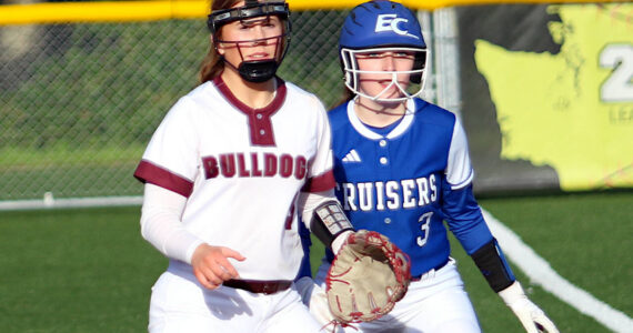 RYAN SPARKS | THE DAILY WORLD Montesano first baseman Grace Gooding, left, and Eatonville’s Zoe Burns look in toward home plate during the Bulldogs’ 12-0 victory on Tuesday in Montesano.