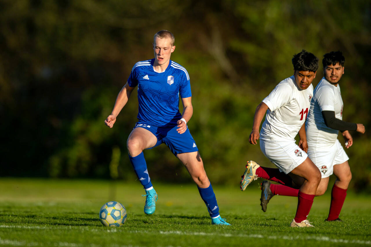 PHOTO BY FOREST WORGUM Elma senior forward Cason Seaberg, left, dribbles away from Hoquiam’s Gilbert Rodriguez Madrigal (11) during the Eagles’ 4-0 win on Wednesday in Elma. Seaberg had a hat trick and now has 95 goals in his prep career.