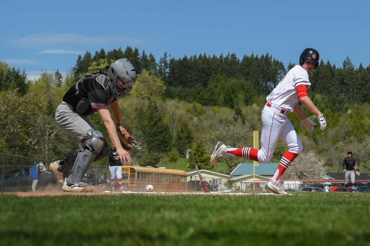 KODY CHRISTEN | THE CHRONICLE Montesano catcher Colton Grubb, left, reaches for the ball while Tenino’s Mikey Vasser runs to first base during a double header on Saturday in Tenino.