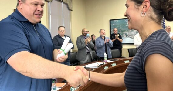 Hoquiam Mayor Ben Winkelman, left, congratulates Jane Roloff, a Hoquiam High School senior, for her exceptionally long list of athletic accolades through not only the 2023-24 school year, but her whole career as a Hoquiam Grizzly. Roloff will start attending the University of Portland this fall. "Jane Roloff's continued success and improvements also bring immense pride to the community, where it had been nearly 30 years since we last held an individual cross country state title," Winkelman read as part of his proclamation that thoroughly recognized Roloff's almost endless list of accolades. (Matthew N. Wells / The Daily World)