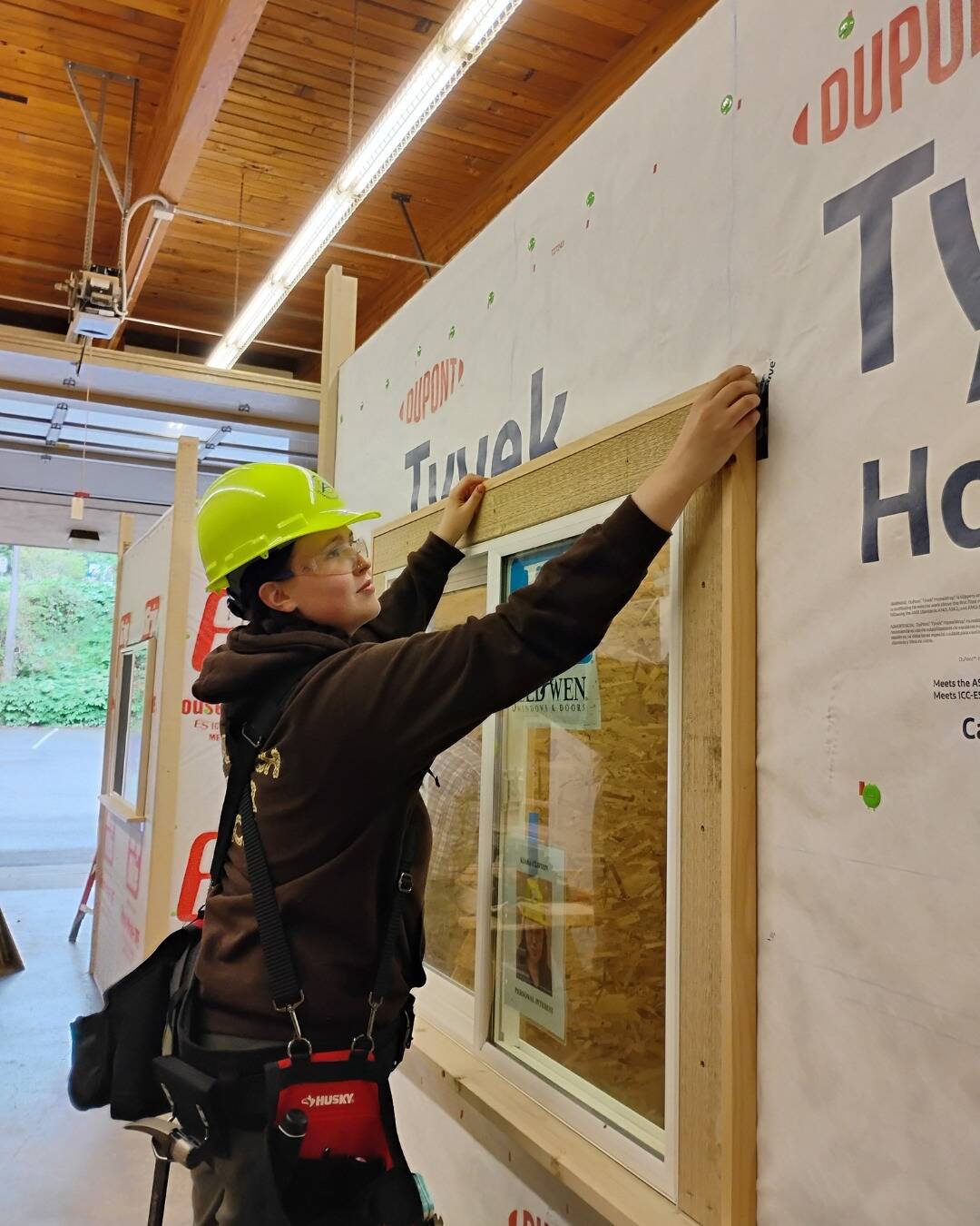 A carpentry student frames in a window.