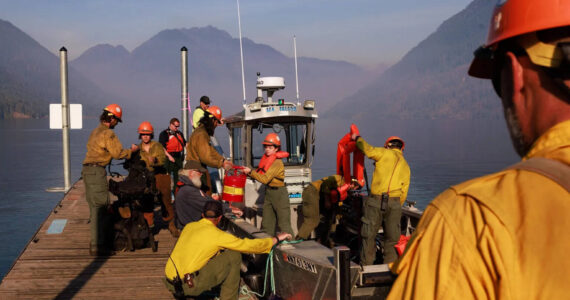 Erika Schultz / The Seattle Times
The Zigzag Interagency Hotshot Crew gets ready to cross Lake Cushman on Thursday to work on the Bear Gulch fire. This day, the wildland firefighters were improving space around homes on the northwest side of the lake.