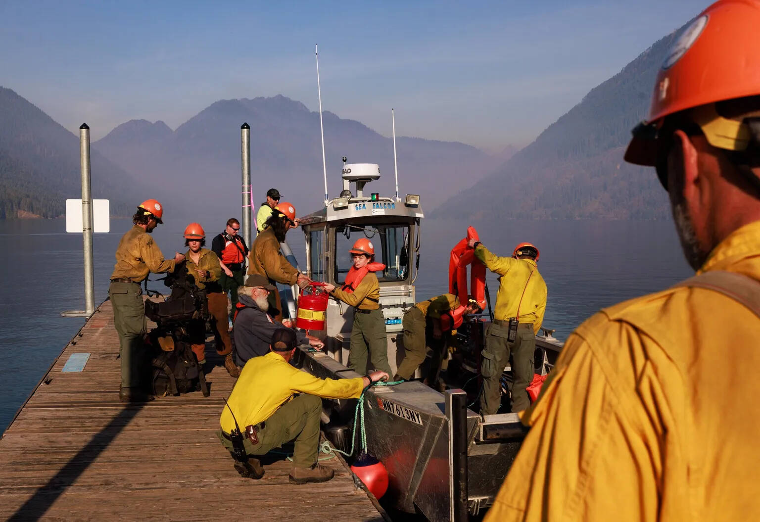 Erika Schultz / The Seattle Times
The Zigzag Interagency Hotshot Crew gets ready to cross Lake Cushman on Thursday to work on the Bear Gulch fire. This day, the wildland firefighters were improving space around homes on the northwest side of the lake.