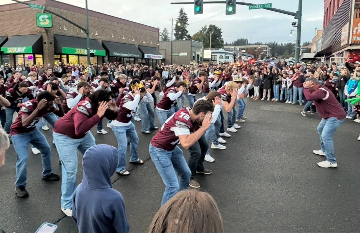 Montesano football players perform reaction drills at intersection of Pioneer and Main in downtown Montesano at the 2025 Homecoming Parade. (The Daily World)