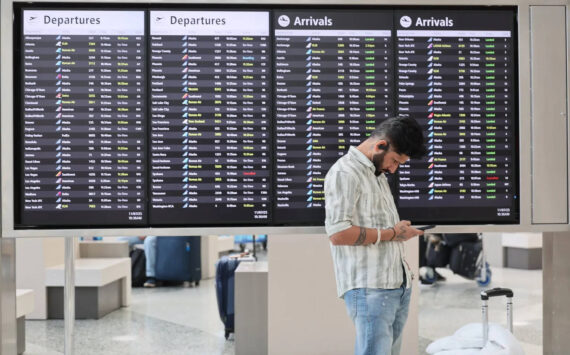 Kevin Clark / The Seattle Times
A traveler at the international ticker board Friday morning at Seattle-Tacoma International Airport in SeaTac on November 7. The FAA has reduced flights by 10% out of the nation’s 40 busiest airports, including SEA.