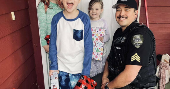 The Daily World file photo
Sgt. Stephen Heller helps distribute toys during last year’s Grays Harbor County Sheriff’s Department Holiday Toy Drive.