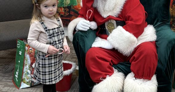 Jerry Knaak / The Daily World
Santa Claus poses for a photo with a shy young visitor at the Ocean Shores Public Library.