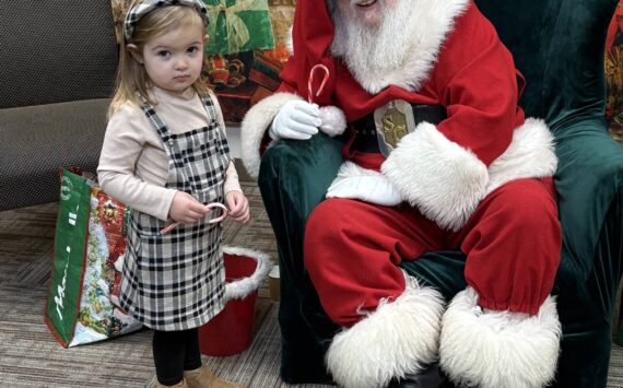 Jerry Knaak / The Daily World
Santa Claus poses for a photo with a shy young visitor at the Ocean Shores Public Library.