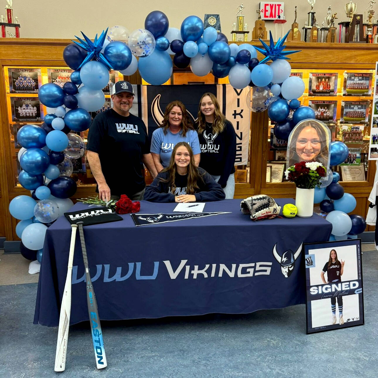 SUBMITTED PHOTO
Pe Ell-Willapa Valley senior softball star Lauren Matlock (sitting) signed a National Letter of Intent to play for Western Washington University at a ceremony on Dec. 15 at Willapa Valley High School. Matlock is the reigning co-2B Pacific League MVP and batted .639 with 60 runs, eight triple and five home runs in her junior season. A starter since eighth-grade, Matlock helped the Titans win a state title in 2022, along with older sister and current WWU first baseman Olivia Matlock (pictured, right), and is a four-time Pac League First Team player. Also pictured are father Pat Matlock (standing, left) and mother Torrie Matlock (standing, middle).
