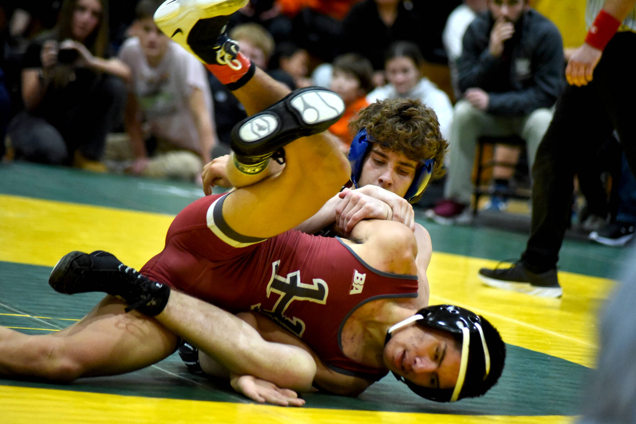 PHOTO BY SUE MICHALAK BUDSBERG Elmas Aidyn Johnson (background) and Hoquiams Junior Balagot wrestle in the 126-pound championship match of The Rock Tournament on Tuesday at Vashon Island High School.