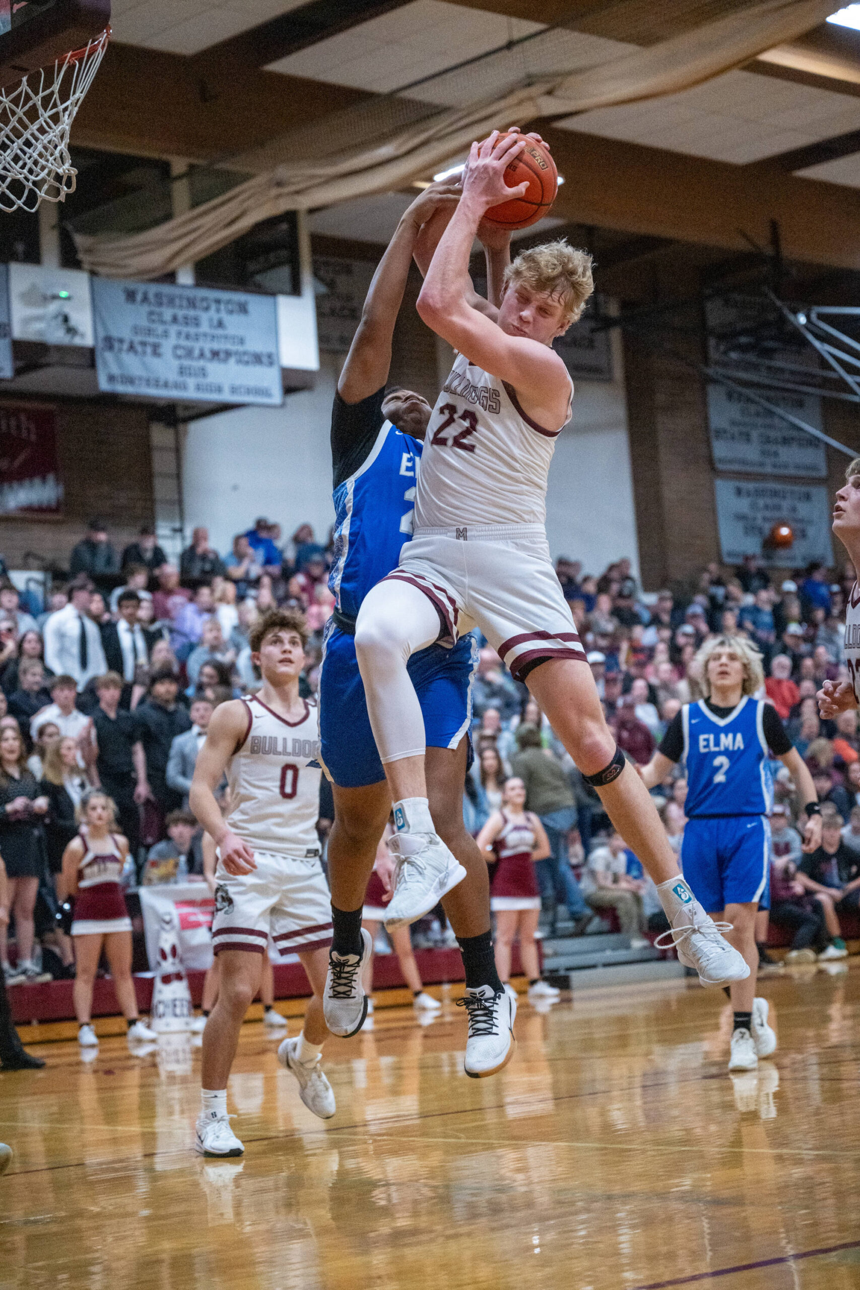 PHOTO BY FOREST WORGUM Montesanos Mason Fry (22) leaps to grab a rebound against Elmas Tyrone Aguilar during the Bulldogs 54-32 victory on Friday at Montesano High School.