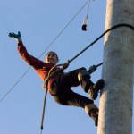 (Corey Morris | Grays Harbor Newspaper Group) Erin Lavoie of Spokane waves to the crowd from the top of the pole during the novice climb event. Lavoie won the event during the 52nd Loggers Playday on Sept. 10 in Hoquiam.