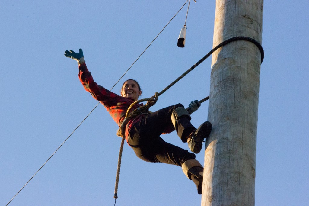 (Corey Morris | Grays Harbor Newspaper Group) Erin Lavoie of Spokane waves to the crowd from the top of the pole during the novice climb event. Lavoie won the event during the 52nd Loggers Playday on Sept. 10 in Hoquiam.